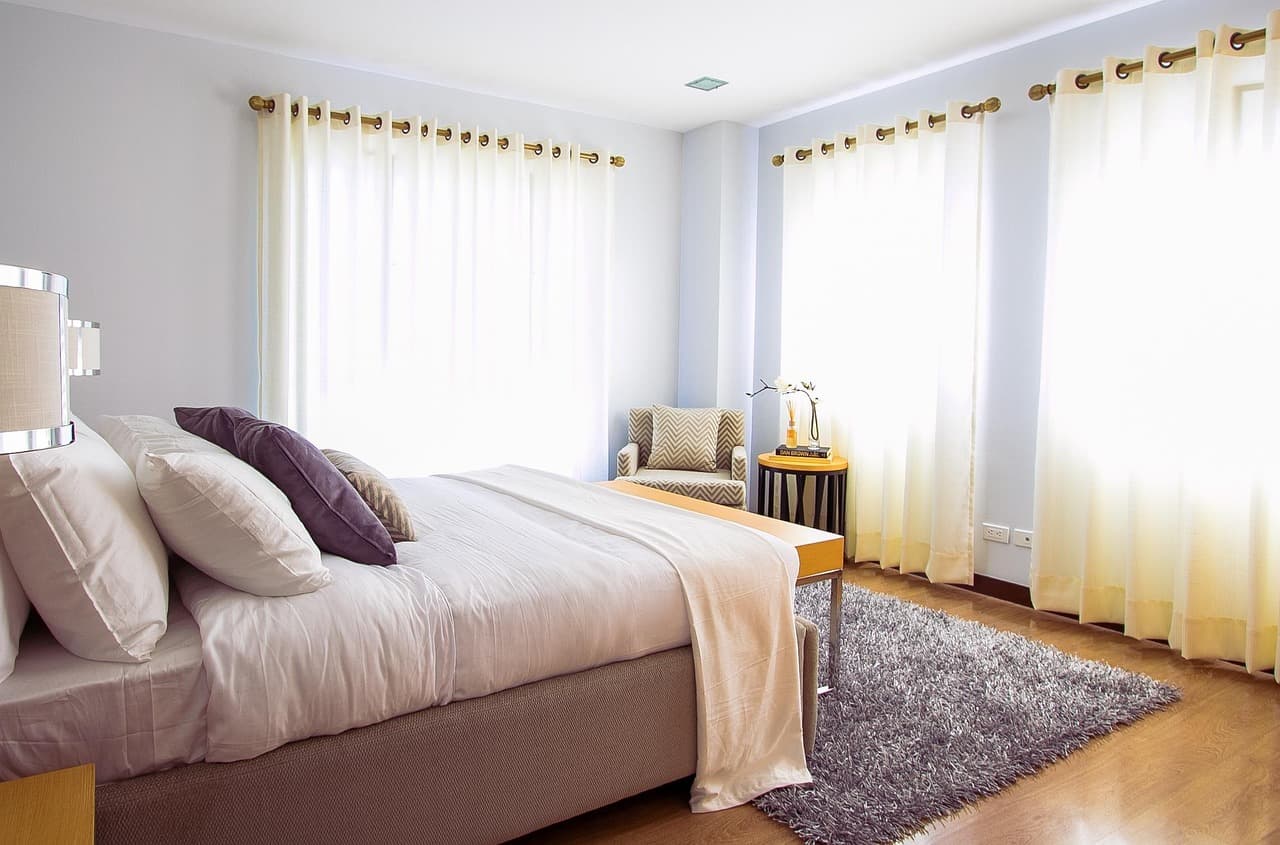 Bright bedroom with long curtains and freshly painted walls